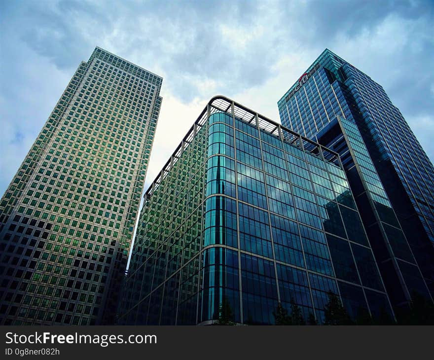 A trio of skyscrapers with glass window exteriors against the blue skies. A trio of skyscrapers with glass window exteriors against the blue skies.