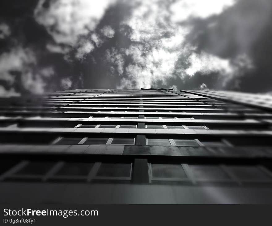 A low-angle view of a high-rise building in black and white. A low-angle view of a high-rise building in black and white.