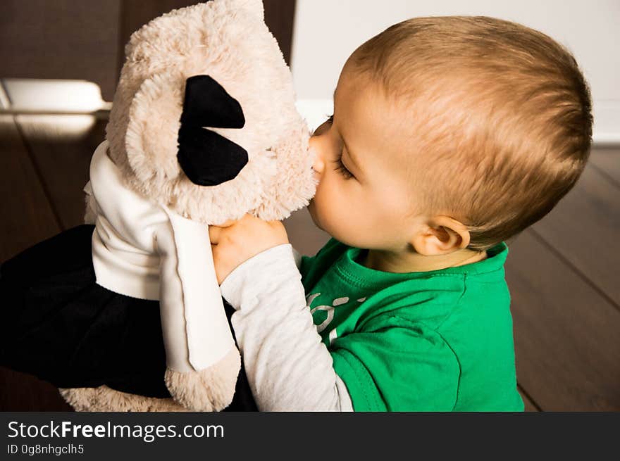 A close up of a toddler boy kissing a teddy bear. A close up of a toddler boy kissing a teddy bear.