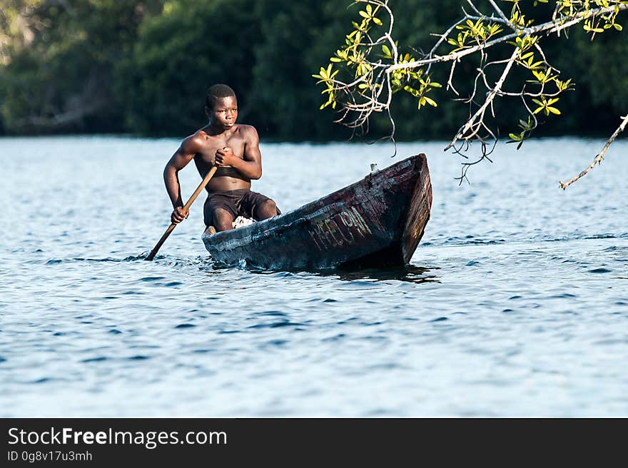 Man in Black Shorts Riding Rowboat during Daytime