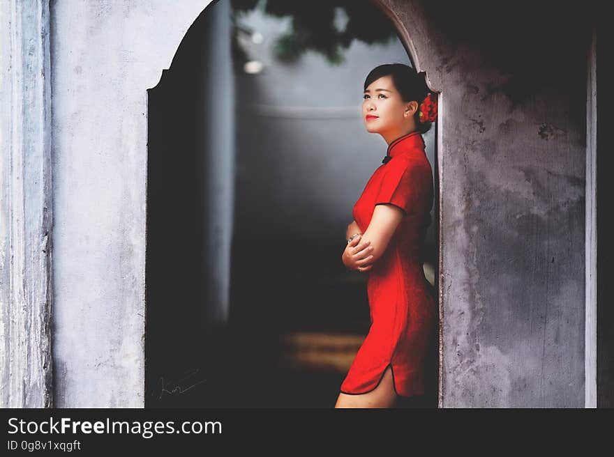 Woman in Red Mini Dress Leaning on Wall