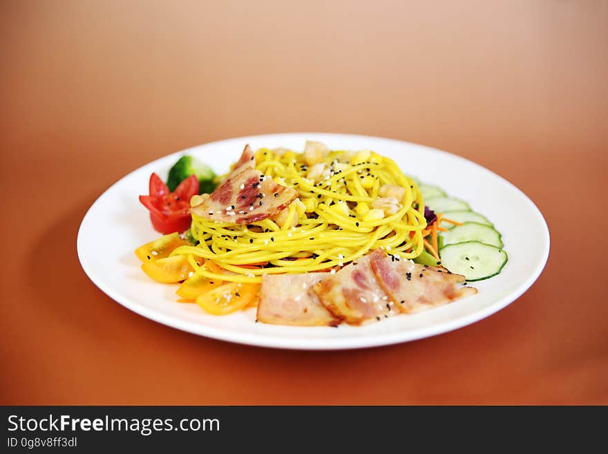 A plate of pasta with vegetables and meat.