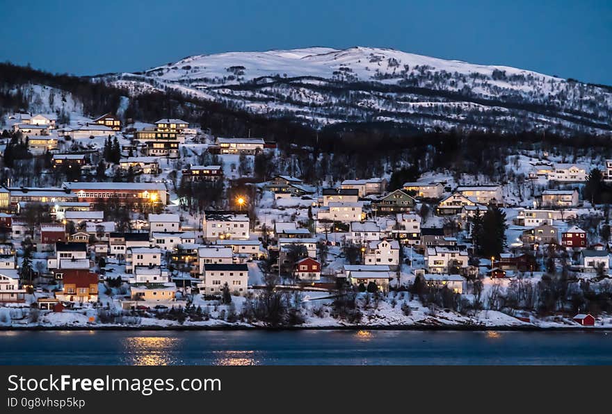 Town on the coastline of snowy Norway viewed from sea at night. Town on the coastline of snowy Norway viewed from sea at night.