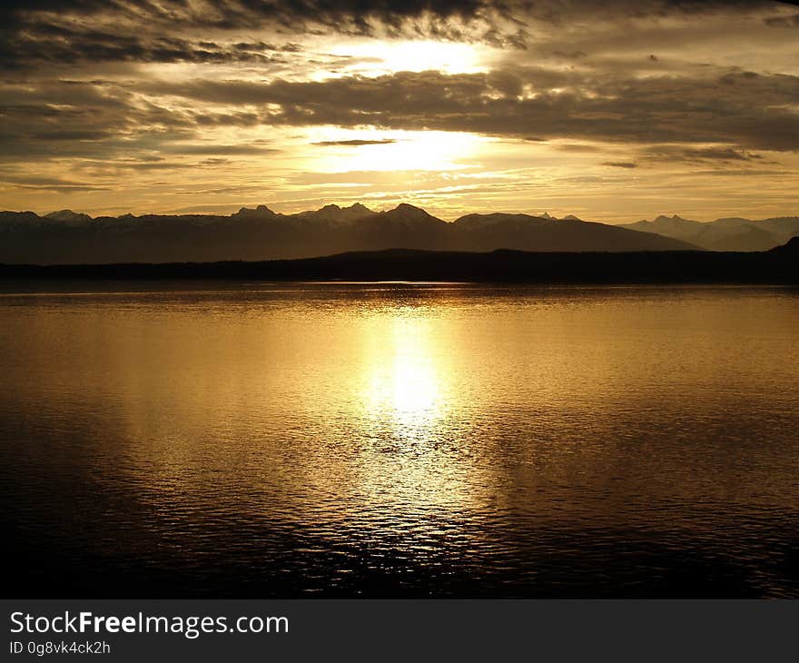 Calm Sea Near Mountain at Sunset