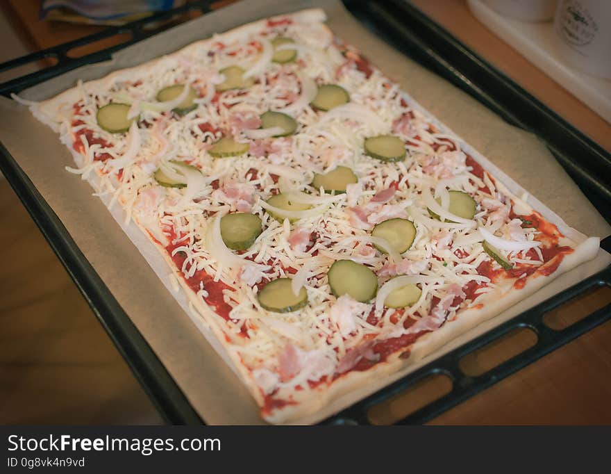 A close up of a homemade pizza on a baking tray.