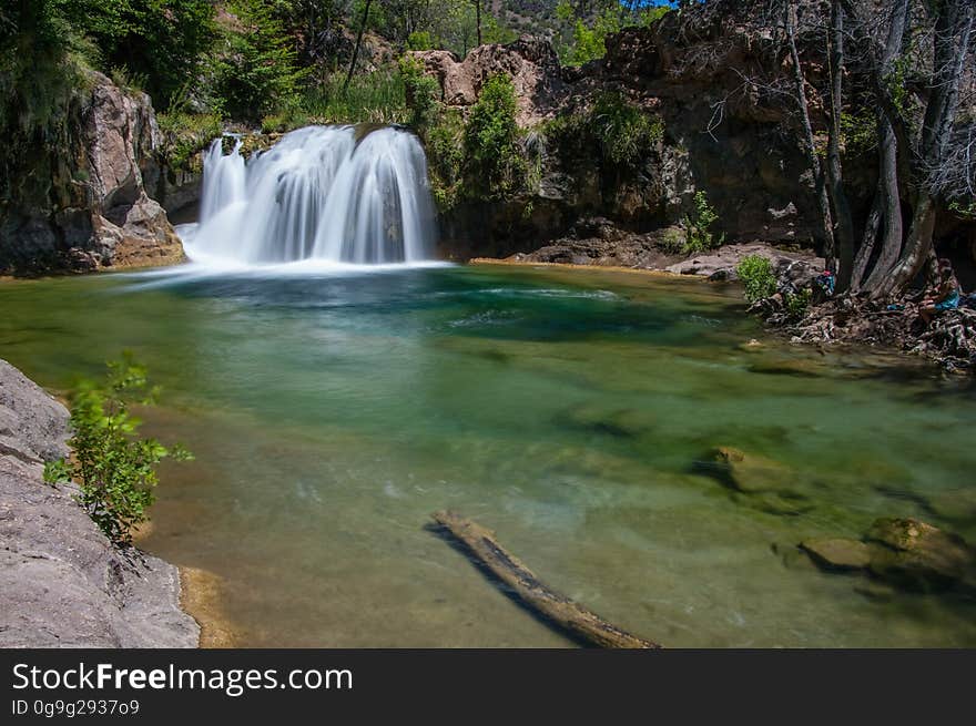 This large, natural waterfall on Fossil Creek is the destination of an easy, one mile hike on Waterfall Trail. A large, deep pool at the base of the fall is a popular swimming hole. Fossil Creek produces 20,000 gallons of water a minute from a series of springs at the bottom of a 1,600 foot deep canyon. This permanent water source has created a stunningly beautiful, green riparian zone rich with flora and fauna at the bottom of this arid canyon in Arizona&#x27;s high desert. Travertine deposits encase whatever happens to fall into the streambed, forming the fossils for which the area is named. These deposits create deep pools along the length of the creek, providing opportunities to find more secluded swimming holes than the popular pool at the waterfall. Fossil Creek is one of two &quot;Wild and Scenic&quot; rivers in Arizona. This designation was achieved when the Irving power plant was decommissioned, and removal of flume and dam on the creek allowed the creek to flow free. Increasing popularity has led to the Coconino and Tonto National Forests to implement a parking permit reservation system in 2016. Reserved parking permits allow visitors to have a parking spot available in their chosen parking lot. Many visitors drive two or three hours to get to the creek. The final descent to the creek at the bottom of a canyon is on an extremely rough, rocky jeep road. In prior years, the area would often be closed to entry when it reached capacity, and potential visitors would be turned away after the long, difficult drive. Photo by Deborah Lee Soltesz, May 12, 2016. For trail and recreation information, see Fossil Creek, Fossil Springs Wilderness, and the Coconino National Forest. This large, natural waterfall on Fossil Creek is the destination of an easy, one mile hike on Waterfall Trail. A large, deep pool at the base of the fall is a popular swimming hole. Fossil Creek produces 20,000 gallons of water a minute from a series of springs at the bottom of a 1,600 foot deep canyon. This permanent water source has created a stunningly beautiful, green riparian zone rich with flora and fauna at the bottom of this arid canyon in Arizona&#x27;s high desert. Travertine deposits encase whatever happens to fall into the streambed, forming the fossils for which the area is named. These deposits create deep pools along the length of the creek, providing opportunities to find more secluded swimming holes than the popular pool at the waterfall. Fossil Creek is one of two &quot;Wild and Scenic&quot; rivers in Arizona. This designation was achieved when the Irving power plant was decommissioned, and removal of flume and dam on the creek allowed the creek to flow free. Increasing popularity has led to the Coconino and Tonto National Forests to implement a parking permit reservation system in 2016. Reserved parking permits allow visitors to have a parking spot available in their chosen parking lot. Many visitors drive two or three hours to get to the creek. The final descent to the creek at the bottom of a canyon is on an extremely rough, rocky jeep road. In prior years, the area would often be closed to entry when it reached capacity, and potential visitors would be turned away after the long, difficult drive. Photo by Deborah Lee Soltesz, May 12, 2016. For trail and recreation information, see Fossil Creek, Fossil Springs Wilderness, and the Coconino National Forest.