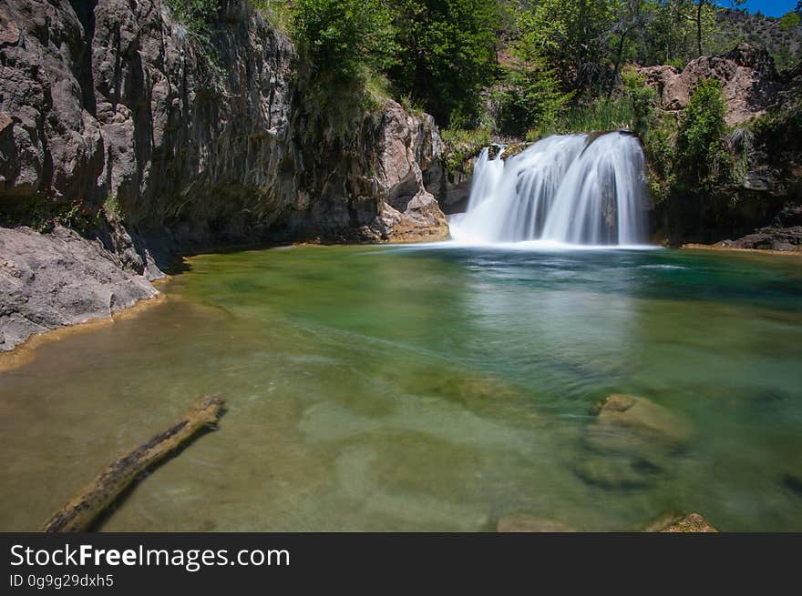 This large, natural waterfall on Fossil Creek is the destination of an easy, one mile hike on Waterfall Trail. A large, deep pool at the base of the fall is a popular swimming hole. Fossil Creek produces 20,000 gallons of water a minute from a series of springs at the bottom of a 1,600 foot deep canyon. This permanent water source has created a stunningly beautiful, green riparian zone rich with flora and fauna at the bottom of this arid canyon in Arizona&#x27;s high desert. Travertine deposits encase whatever happens to fall into the streambed, forming the fossils for which the area is named. These deposits create deep pools along the length of the creek, providing opportunities to find more secluded swimming holes than the popular pool at the waterfall. Fossil Creek is one of two &quot;Wild and Scenic&quot; rivers in Arizona. This designation was achieved when the Irving power plant was decommissioned, and removal of flume and dam on the creek allowed the creek to flow free. Increasing popularity has led to the Coconino and Tonto National Forests to implement a parking permit reservation system in 2016. Reserved parking permits allow visitors to have a parking spot available in their chosen parking lot. Many visitors drive two or three hours to get to the creek. The final descent to the creek at the bottom of a canyon is on an extremely rough, rocky jeep road. In prior years, the area would often be closed to entry when it reached capacity, and potential visitors would be turned away after the long, difficult drive. Photo by Deborah Lee Soltesz, May 12, 2016. For trail and recreation information, see Fossil Creek, Fossil Springs Wilderness, and the Coconino National Forest. This large, natural waterfall on Fossil Creek is the destination of an easy, one mile hike on Waterfall Trail. A large, deep pool at the base of the fall is a popular swimming hole. Fossil Creek produces 20,000 gallons of water a minute from a series of springs at the bottom of a 1,600 foot deep canyon. This permanent water source has created a stunningly beautiful, green riparian zone rich with flora and fauna at the bottom of this arid canyon in Arizona&#x27;s high desert. Travertine deposits encase whatever happens to fall into the streambed, forming the fossils for which the area is named. These deposits create deep pools along the length of the creek, providing opportunities to find more secluded swimming holes than the popular pool at the waterfall. Fossil Creek is one of two &quot;Wild and Scenic&quot; rivers in Arizona. This designation was achieved when the Irving power plant was decommissioned, and removal of flume and dam on the creek allowed the creek to flow free. Increasing popularity has led to the Coconino and Tonto National Forests to implement a parking permit reservation system in 2016. Reserved parking permits allow visitors to have a parking spot available in their chosen parking lot. Many visitors drive two or three hours to get to the creek. The final descent to the creek at the bottom of a canyon is on an extremely rough, rocky jeep road. In prior years, the area would often be closed to entry when it reached capacity, and potential visitors would be turned away after the long, difficult drive. Photo by Deborah Lee Soltesz, May 12, 2016. For trail and recreation information, see Fossil Creek, Fossil Springs Wilderness, and the Coconino National Forest.