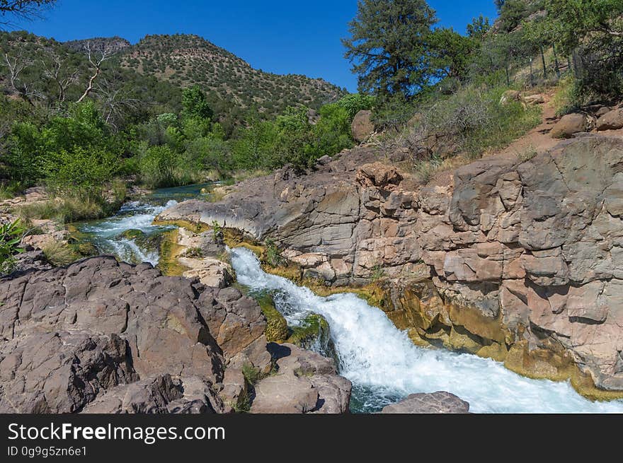 Fossil Creek produces 20,000 gallons of water a minute from a series of springs at the bottom of a 1,600 foot deep canyon. This permanent water source has created a stunningly beautiful, green riparian zone rich with flora and fauna at the bottom of this arid canyon in Arizona&#x27;s high desert. Travertine deposits encase whatever happens to fall into the streambed, forming the fossils for which the area is named. These deposits create deep pools along the length of the creek, providing opportunities to find more secluded swimming holes than the popular pool at the waterfall. Fossil Creek is one of two &quot;Wild and Scenic&quot; rivers in Arizona. This designation was achieved when the Irving power plant was decommissioned, and removal of flume and dam on the creek allowed the creek to flow free. Increasing popularity has led to the Coconino and Tonto National Forests to implement a parking permit reservation system in 2016. Reserved parking permits allow visitors to have a parking spot available in their chosen parking lot. Many visitors drive two or three hours to get to the creek. The final descent to the creek at the bottom of a canyon is on an extremely rough, rocky jeep road. In prior years, the area would often be closed to entry when it reached capacity, and potential visitors would be turned away after the long, difficult drive. Photo by Deborah Lee Soltesz, May 4, 2016. For trail and recreation information, see Fossil Creek, Fossil Springs Wilderness, and the Coconino National Forest. Fossil Creek produces 20,000 gallons of water a minute from a series of springs at the bottom of a 1,600 foot deep canyon. This permanent water source has created a stunningly beautiful, green riparian zone rich with flora and fauna at the bottom of this arid canyon in Arizona&#x27;s high desert. Travertine deposits encase whatever happens to fall into the streambed, forming the fossils for which the area is named. These deposits create deep pools along the length of the creek, providing opportunities to find more secluded swimming holes than the popular pool at the waterfall. Fossil Creek is one of two &quot;Wild and Scenic&quot; rivers in Arizona. This designation was achieved when the Irving power plant was decommissioned, and removal of flume and dam on the creek allowed the creek to flow free. Increasing popularity has led to the Coconino and Tonto National Forests to implement a parking permit reservation system in 2016. Reserved parking permits allow visitors to have a parking spot available in their chosen parking lot. Many visitors drive two or three hours to get to the creek. The final descent to the creek at the bottom of a canyon is on an extremely rough, rocky jeep road. In prior years, the area would often be closed to entry when it reached capacity, and potential visitors would be turned away after the long, difficult drive. Photo by Deborah Lee Soltesz, May 4, 2016. For trail and recreation information, see Fossil Creek, Fossil Springs Wilderness, and the Coconino National Forest.