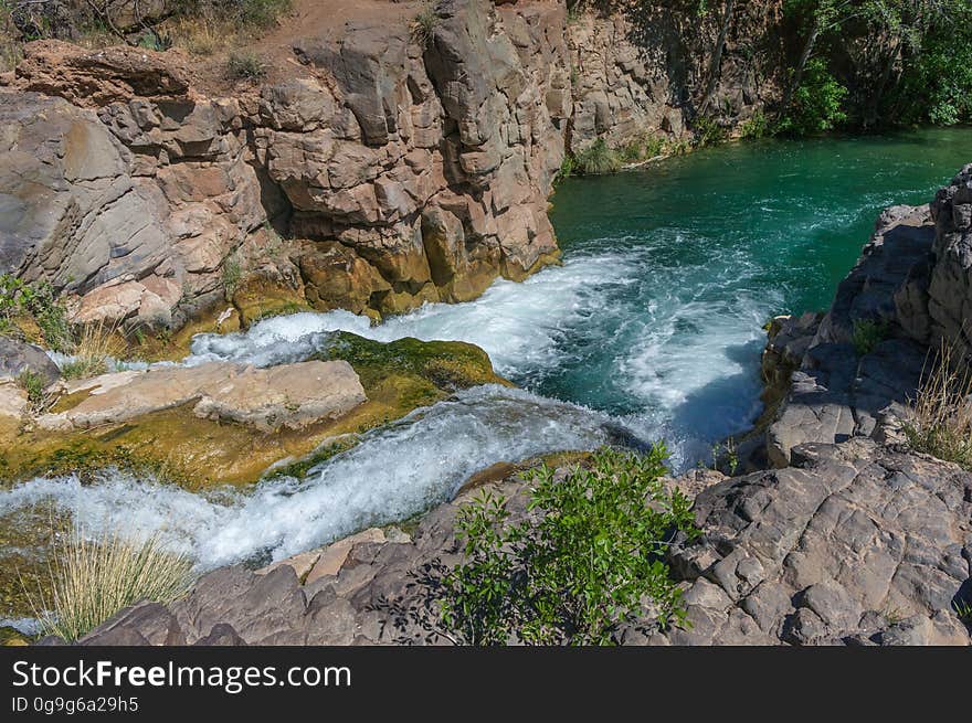 Fossil Creek produces 20,000 gallons of water a minute from a series of springs at the bottom of a 1,600 foot deep canyon. This permanent water source has created a stunningly beautiful, green riparian zone rich with flora and fauna at the bottom of this arid canyon in Arizona&#x27;s high desert. Travertine deposits encase whatever happens to fall into the streambed, forming the fossils for which the area is named. These deposits create deep pools along the length of the creek, providing opportunities to find more secluded swimming holes than the popular pool at the waterfall. Fossil Creek is one of two &quot;Wild and Scenic&quot; rivers in Arizona. This designation was achieved when the Irving power plant was decommissioned, and removal of flume and dam on the creek allowed the creek to flow free. Increasing popularity has led to the Coconino and Tonto National Forests to implement a parking permit reservation system in 2016. Reserved parking permits allow visitors to have a parking spot available in their chosen parking lot. Many visitors drive two or three hours to get to the creek. The final descent to the creek at the bottom of a canyon is on an extremely rough, rocky jeep road. In prior years, the area would often be closed to entry when it reached capacity, and potential visitors would be turned away after the long, difficult drive. Photo by Deborah Lee Soltesz, May 4, 2016. For trail and recreation information, see Fossil Creek, Fossil Springs Wilderness, and the Coconino National Forest. Fossil Creek produces 20,000 gallons of water a minute from a series of springs at the bottom of a 1,600 foot deep canyon. This permanent water source has created a stunningly beautiful, green riparian zone rich with flora and fauna at the bottom of this arid canyon in Arizona&#x27;s high desert. Travertine deposits encase whatever happens to fall into the streambed, forming the fossils for which the area is named. These deposits create deep pools along the length of the creek, providing opportunities to find more secluded swimming holes than the popular pool at the waterfall. Fossil Creek is one of two &quot;Wild and Scenic&quot; rivers in Arizona. This designation was achieved when the Irving power plant was decommissioned, and removal of flume and dam on the creek allowed the creek to flow free. Increasing popularity has led to the Coconino and Tonto National Forests to implement a parking permit reservation system in 2016. Reserved parking permits allow visitors to have a parking spot available in their chosen parking lot. Many visitors drive two or three hours to get to the creek. The final descent to the creek at the bottom of a canyon is on an extremely rough, rocky jeep road. In prior years, the area would often be closed to entry when it reached capacity, and potential visitors would be turned away after the long, difficult drive. Photo by Deborah Lee Soltesz, May 4, 2016. For trail and recreation information, see Fossil Creek, Fossil Springs Wilderness, and the Coconino National Forest.