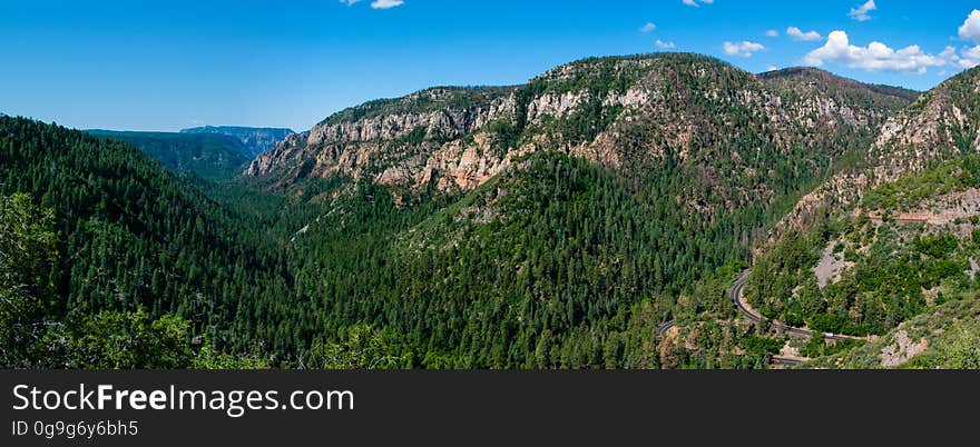 Oak Creek Canyon is a gorge carved into the edge of the Mogollon Rim of the Colorado Plateau along the Oak Creek Fault. Tectonic forces shifting the land to either side of the fault and subsequent erosion by Oak Creek have created a spectacular canyon where the geologic history of this area is an open book. The Canyon is approximately 12 miles long. Oak Creek flows year-round along the bottom of the Canyon, providing water for plants and wildlife, as well as fishing and swimming opportunities. Oak Creek continues on through Sedona, Arizona, meeting up with the Verde River southeast of Cottonwood, Arizona. The depth of the Canyon ranges from 800 to 2000 feet, with trails providing access from the Canyon’s bottom up to the 6500-foot eastern rim and 7200-foot western rim. Some of these trails follow historic routes early Oak Creek Canyon settlers used to access the top of the plateau in the days before the road was built. Trails on the west side of the Canyon head into Red Rock-Secret Mountain Wilderness. Multi-photo panorama by Deborah Lee Soltesz, June 12, 2015. Credit U.S. Forest Service Coconino National Forest. Learn more about Oak Creek Canyon and the Coconino National Forest.