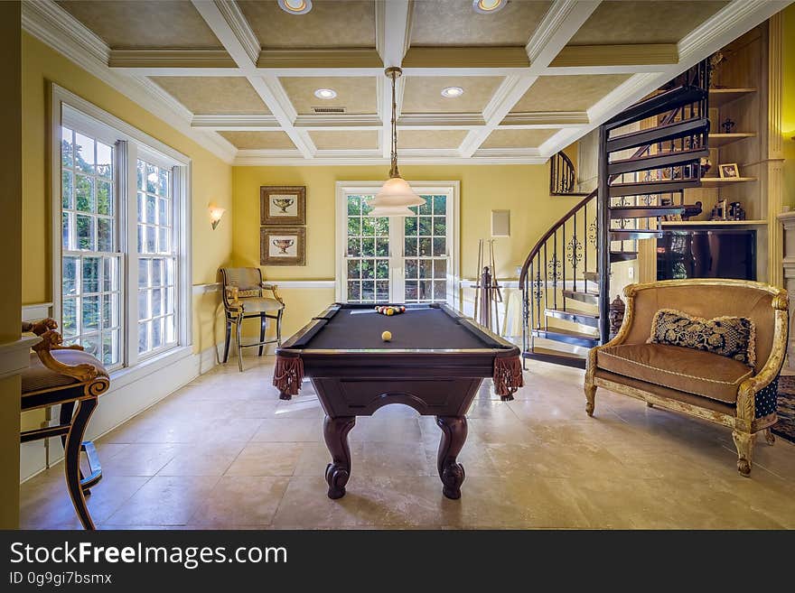 A billiard table in the middle of an elegant room. A billiard table in the middle of an elegant room.