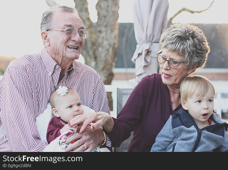 Grandparents sitting outdoor with their grandchildren. Grandparents sitting outdoor with their grandchildren.