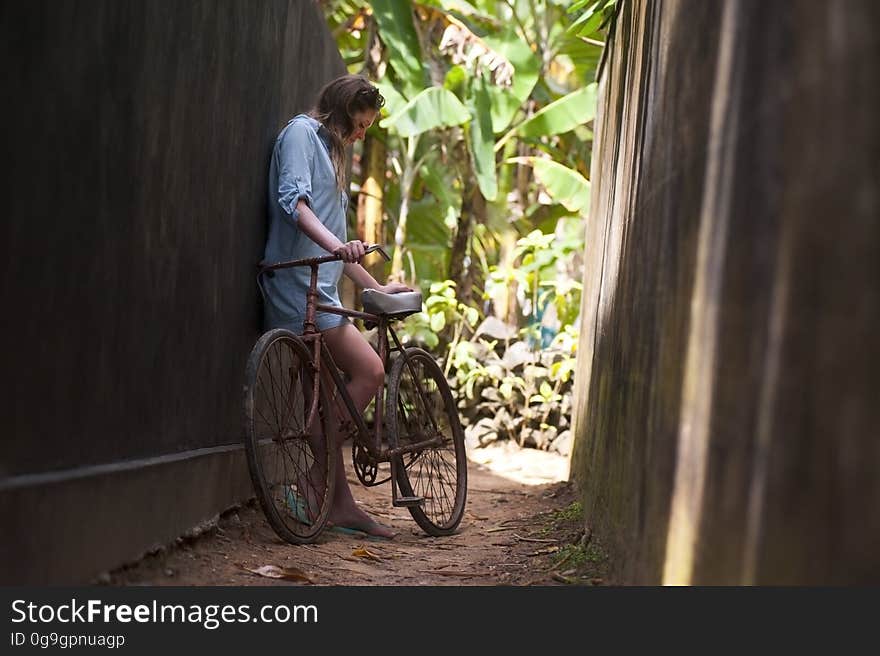 A girl with her bicycle on a narrow alley. A girl with her bicycle on a narrow alley.