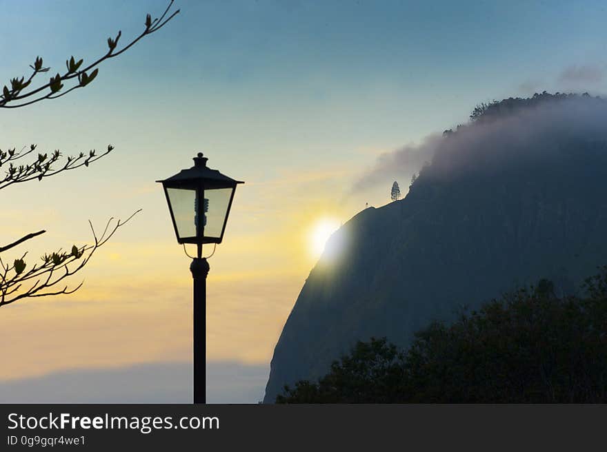 The setting sun behind the silhouette of a hill at sunset. The setting sun behind the silhouette of a hill at sunset.