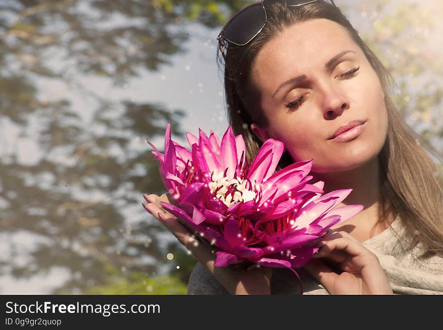 A woman holding red flowers outdoors. A woman holding red flowers outdoors.