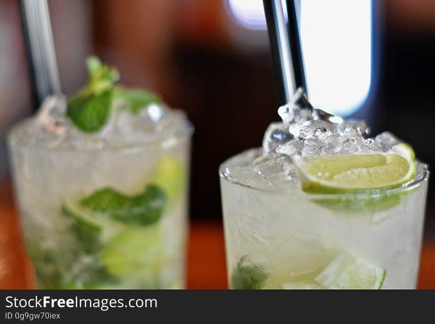 Two iced cocktails garnished with mint and lime. Two iced cocktails garnished with mint and lime.