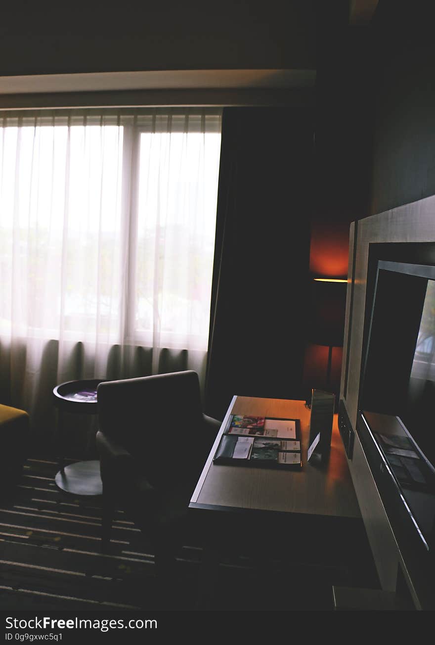 Modern hotel room with tv and desk.