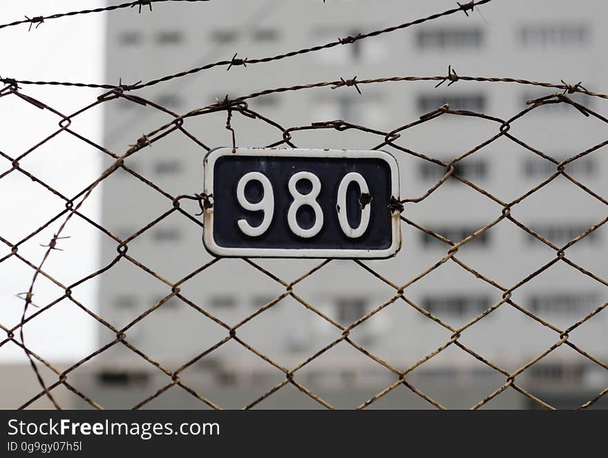 Barbed wire fence with number plate on it. Barbed wire fence with number plate on it.