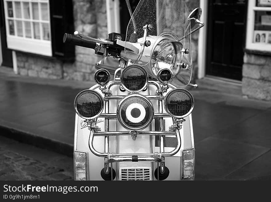 A closeup of a scooter in black and white. A closeup of a scooter in black and white.