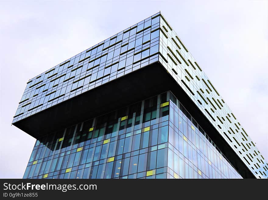 A modern skyscraper in a city against the blue skies with white clouds. A modern skyscraper in a city against the blue skies with white clouds.