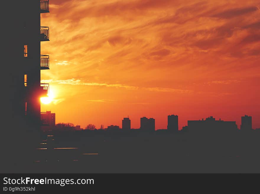 An urban sunset with apartment silhouettes.