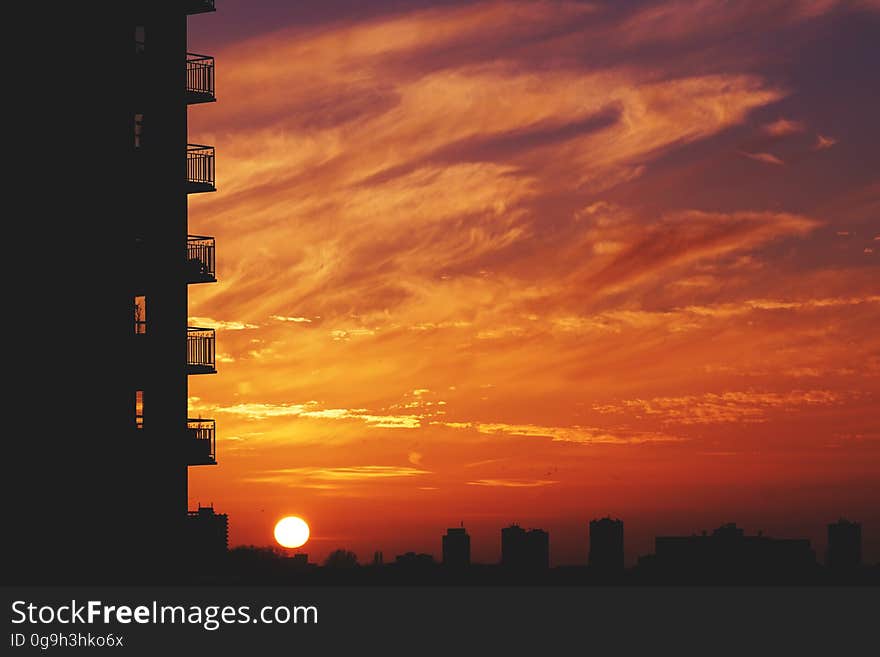 Multi storey apartments with balconies seen in virtual silhouette in the orange glow of sunset. Multi storey apartments with balconies seen in virtual silhouette in the orange glow of sunset.