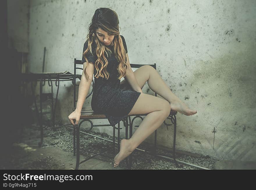 A woman sitting on a chair in an old dilapidated house. A woman sitting on a chair in an old dilapidated house.