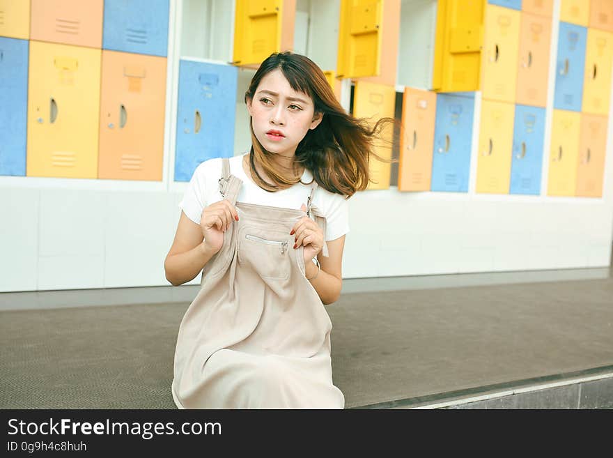 A woman sitting in front of colorful lockers in the locker room. A woman sitting in front of colorful lockers in the locker room.