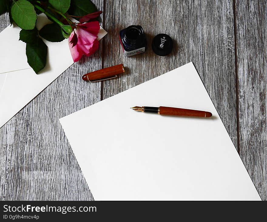 A blank stationery and an envelope with a fountain pen on top. A blank stationery and an envelope with a fountain pen on top.