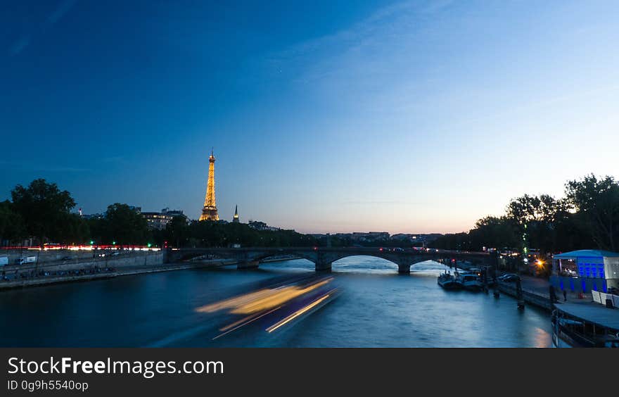 A night view of Paris, France, with boats on the river Seine.