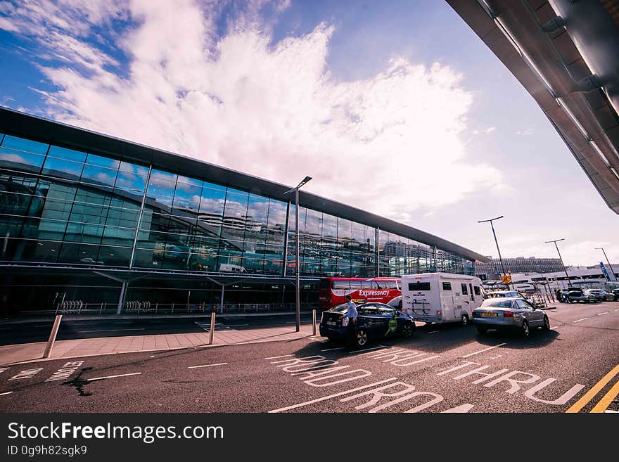 A parking lot next to an commercial building or airport terminal. A parking lot next to an commercial building or airport terminal.