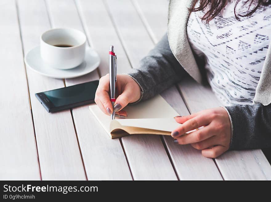 Woman&#x27;s hand using a pen noting on notepad