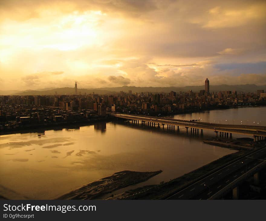 A sunset over a city with river and a bridge. A sunset over a city with river and a bridge.