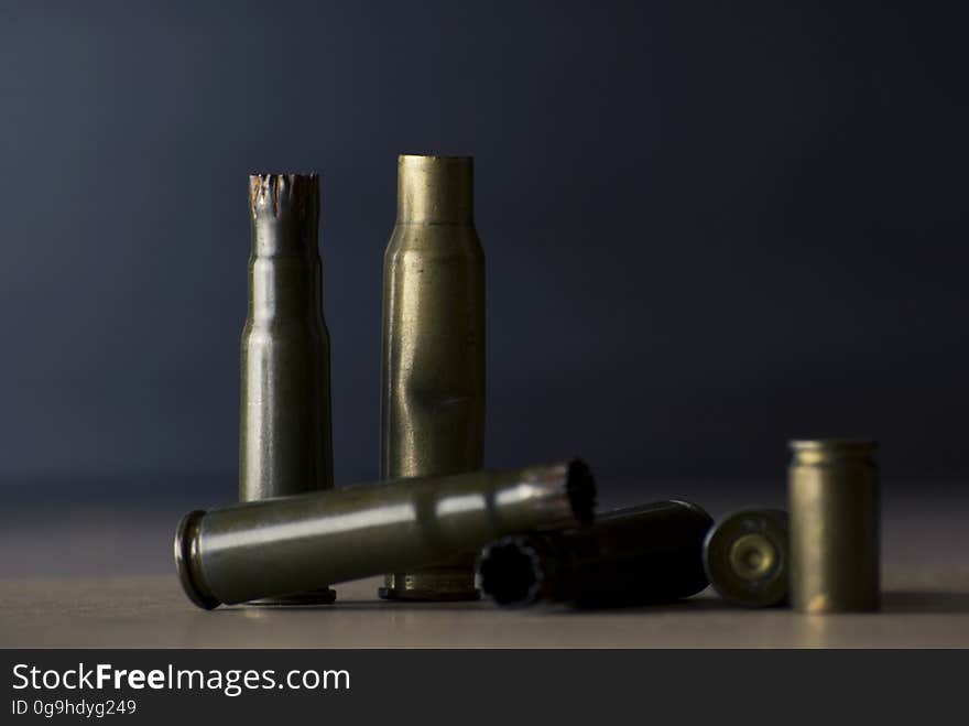 Empty Bullet Shells on Brown Surface