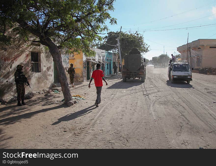 SOMALIA, Kismayo: In a photogaph taken 12 October 2013 and released by the African Union-United Nations Information Support Team 15 October, a Somali man walks down a street during a patrol by Kenyan soldiers serving with the African Union Mission in Somalia &#x28;AMISOM&#x29; in the southern Somali port city of Kismayo. October 16 marks two years since the Kenya Defense Force first intervened in Somalia under Operation Linda Nchi - meaning Operation Protect the Country in Kiswahili - following a series of kidnappings and cross-border raids along the Kenya-Somalia border by the Al-Qaeda-affiliated terrorist group Al Shabaab. KDF forces were fully integrated into the African Union mission on 22 February 2012 and saw them capture the strategically and economiclly important port city of Kismayo from Al Shabaab in early October 2012 after a sustained 6-month advance across southern Somalia. AU/UN IST PHOTO / RAMADAN MOHAMED HASSAN. SOMALIA, Kismayo: In a photogaph taken 12 October 2013 and released by the African Union-United Nations Information Support Team 15 October, a Somali man walks down a street during a patrol by Kenyan soldiers serving with the African Union Mission in Somalia &#x28;AMISOM&#x29; in the southern Somali port city of Kismayo. October 16 marks two years since the Kenya Defense Force first intervened in Somalia under Operation Linda Nchi - meaning Operation Protect the Country in Kiswahili - following a series of kidnappings and cross-border raids along the Kenya-Somalia border by the Al-Qaeda-affiliated terrorist group Al Shabaab. KDF forces were fully integrated into the African Union mission on 22 February 2012 and saw them capture the strategically and economiclly important port city of Kismayo from Al Shabaab in early October 2012 after a sustained 6-month advance across southern Somalia. AU/UN IST PHOTO / RAMADAN MOHAMED HASSAN.