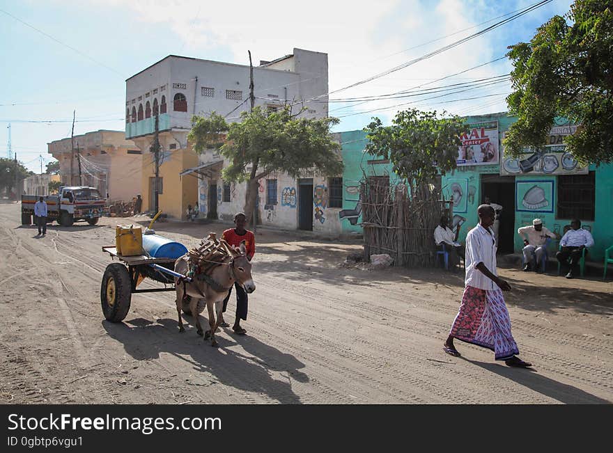 SOMALIA, Kismayo: In a photogaph taken 12 October 2013 and released by the African Union-United Nations Information Support Team 15 October, Somali civilians walk down a street during a patrol by Kenyan soldiers serving with the African Union Mission in Somalia &#x28;AMISOM&#x29; in the southern Somali port city of Kismayo. October 16 marks two years since the Kenya Defense Force first intervened in Somalia under Operation Linda Nchi - meaning Operation Protect the Country in Kiswahili - following a series of kidnappings and cross-border raids along the Kenya-Somalia border by the Al-Qaeda-affiliated terrorist group Al Shabaab. KDF forces were fully integrated into the African Union mission on 22 February 2012 and saw them capture the strategically and economiclly important port city of Kismayo from Al Shabaab in early October 2012 after a sustained 6-month advance across southern Somalia. AU/UN IST PHOTO / RAMADAN MOHAMED HASSAN. SOMALIA, Kismayo: In a photogaph taken 12 October 2013 and released by the African Union-United Nations Information Support Team 15 October, Somali civilians walk down a street during a patrol by Kenyan soldiers serving with the African Union Mission in Somalia &#x28;AMISOM&#x29; in the southern Somali port city of Kismayo. October 16 marks two years since the Kenya Defense Force first intervened in Somalia under Operation Linda Nchi - meaning Operation Protect the Country in Kiswahili - following a series of kidnappings and cross-border raids along the Kenya-Somalia border by the Al-Qaeda-affiliated terrorist group Al Shabaab. KDF forces were fully integrated into the African Union mission on 22 February 2012 and saw them capture the strategically and economiclly important port city of Kismayo from Al Shabaab in early October 2012 after a sustained 6-month advance across southern Somalia. AU/UN IST PHOTO / RAMADAN MOHAMED HASSAN.