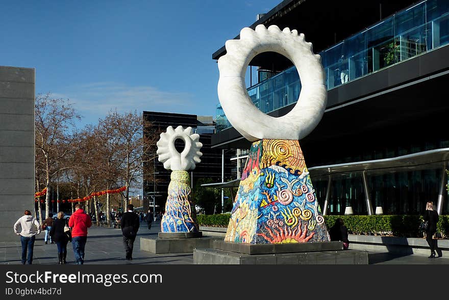 &#x27;THE GUARDIANS&#x27; AT SOUTHBANK Walking along Southbank Promenade, on the southern bank of the Yarra River in the CBD, one can see two large sculptures, called ‘The Guardians’, outside the eastern end of the Crown Entertainment Complex. They are striking and colourful art works that immediately catch the eye and contribute to the appeal of the walk along the Promenade. These two large sculptures are carved from Italian statuary marble and clad with ceramic tiles. They were created in 1997 by the, then local, artist Simon Rigg. The square based mounting of the larger statue depicts the four elements. The smaller Guardian reveals a woman’s head looking through the hole of the larger sculpture, and hints at the source of all the images, beyond our plane of vision. &#x27;THE GUARDIANS&#x27; AT SOUTHBANK Walking along Southbank Promenade, on the southern bank of the Yarra River in the CBD, one can see two large sculptures, called ‘The Guardians’, outside the eastern end of the Crown Entertainment Complex. They are striking and colourful art works that immediately catch the eye and contribute to the appeal of the walk along the Promenade. These two large sculptures are carved from Italian statuary marble and clad with ceramic tiles. They were created in 1997 by the, then local, artist Simon Rigg. The square based mounting of the larger statue depicts the four elements. The smaller Guardian reveals a woman’s head looking through the hole of the larger sculpture, and hints at the source of all the images, beyond our plane of vision.