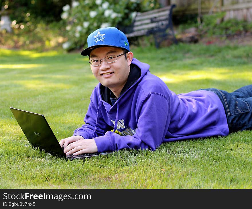 A person on the grass with his laptop out. A person on the grass with his laptop out.