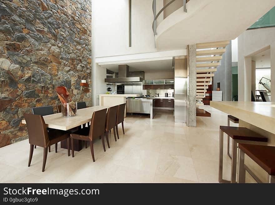 Modern interior in big house with dining room and stone wall. Modern interior in big house with dining room and stone wall