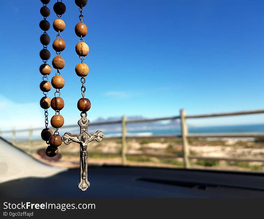 Selective Focus Photo of Brown and Silver Rosary