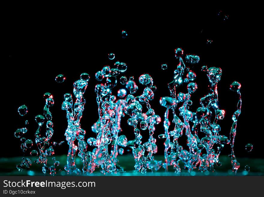 Water droplets closeup, sprayed in an upward direction and viewed against a dark background through a polarizing filter and probably with flash. Water droplets closeup, sprayed in an upward direction and viewed against a dark background through a polarizing filter and probably with flash.