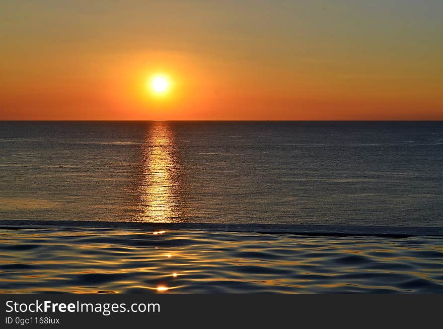 A sunset over the sea with orange skies. A sunset over the sea with orange skies.