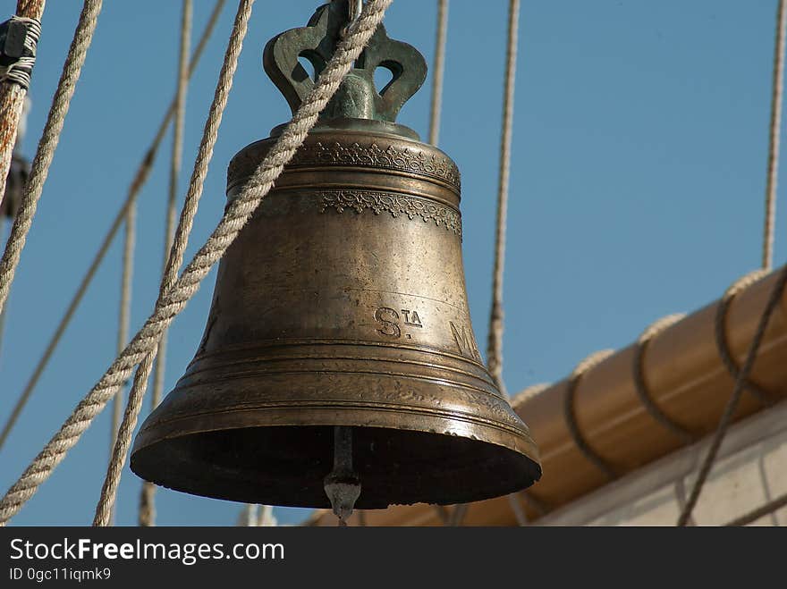 An old ship's bell hanging from the yardarm. An old ship's bell hanging from the yardarm.