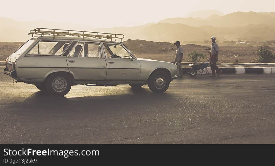 A classic car with luggage rail on top on the street. A classic car with luggage rail on top on the street.