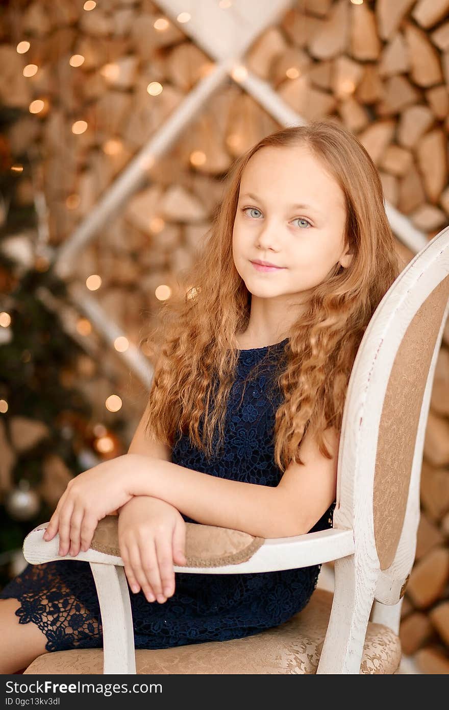 A portrait of a young girl sitting on an antique chair. A portrait of a young girl sitting on an antique chair.