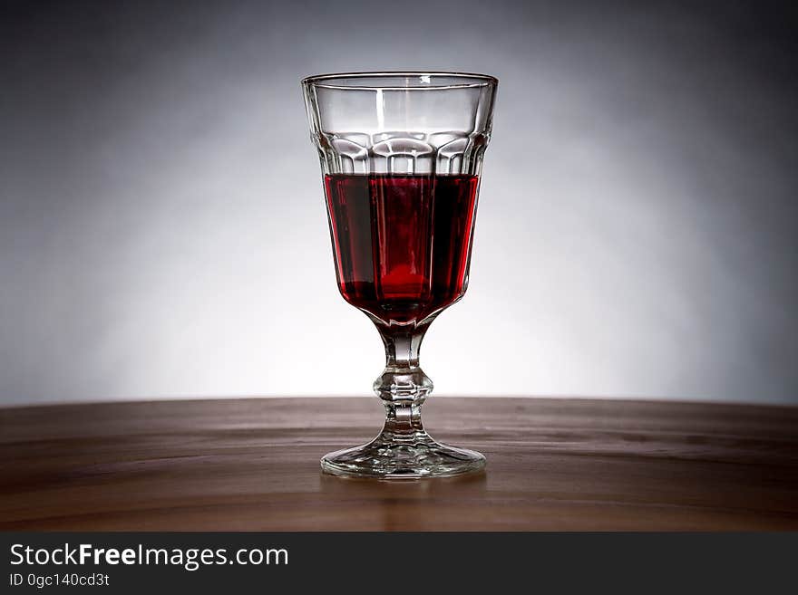 A glass of wine or other red liquid.