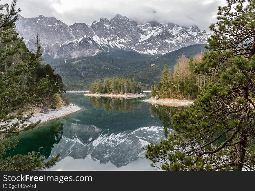 A river passing through an autumn forest with snowy mountains in the distance. A river passing through an autumn forest with snowy mountains in the distance.