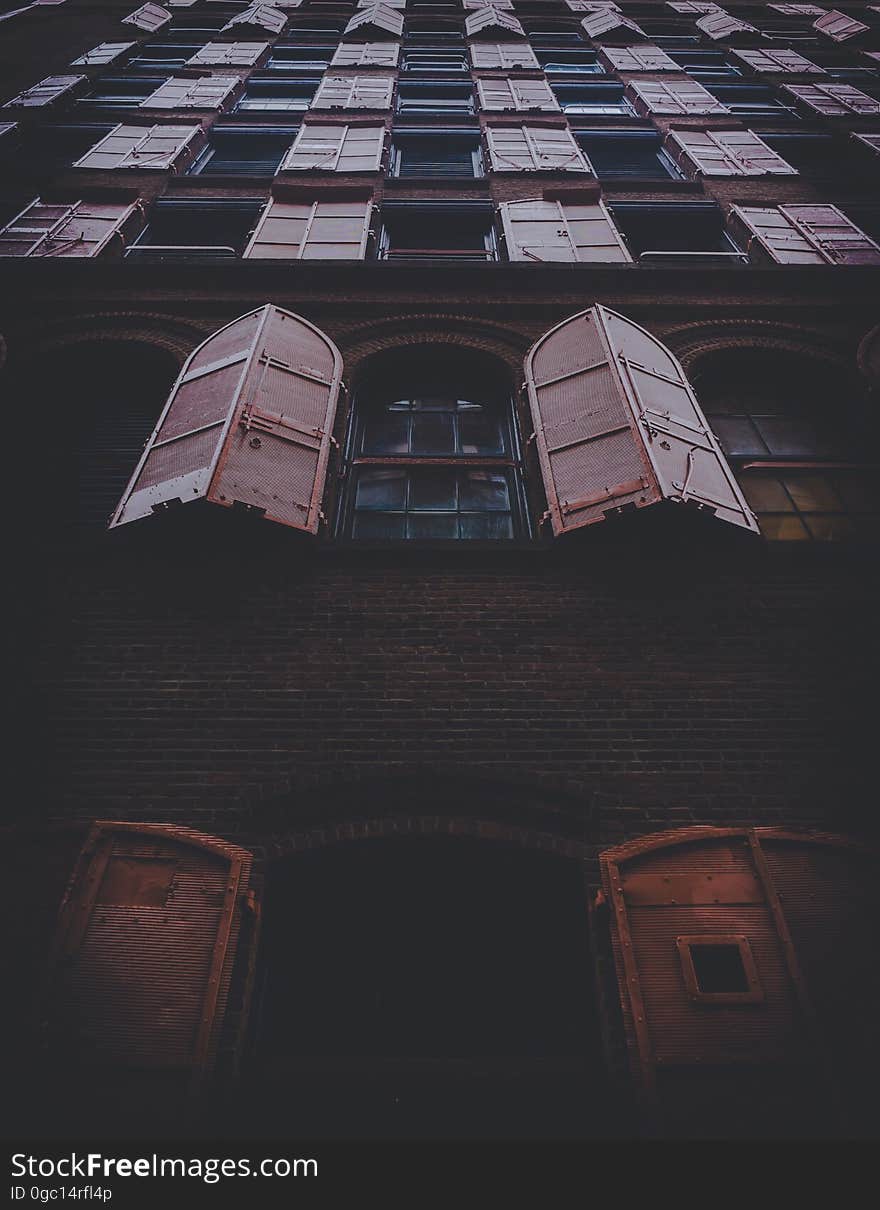 Open shutters on windows on exterior of old building. Open shutters on windows on exterior of old building.