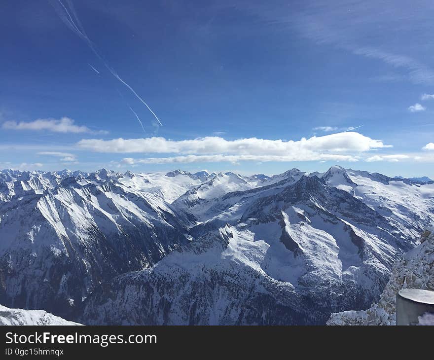 Aerial view over snow capped mountain landscape with blue skies on sunny day. Aerial view over snow capped mountain landscape with blue skies on sunny day.