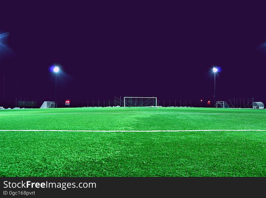 An empty soccer field at night time.